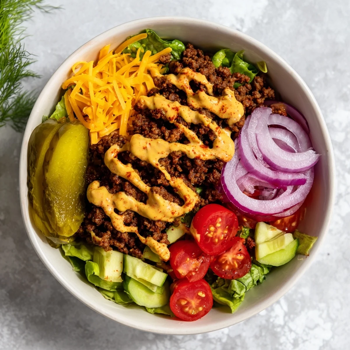 Low-carb burger bowls featuring juicy beef, crisp lettuce, tomatoes, pickles, and tangy homemade sauce