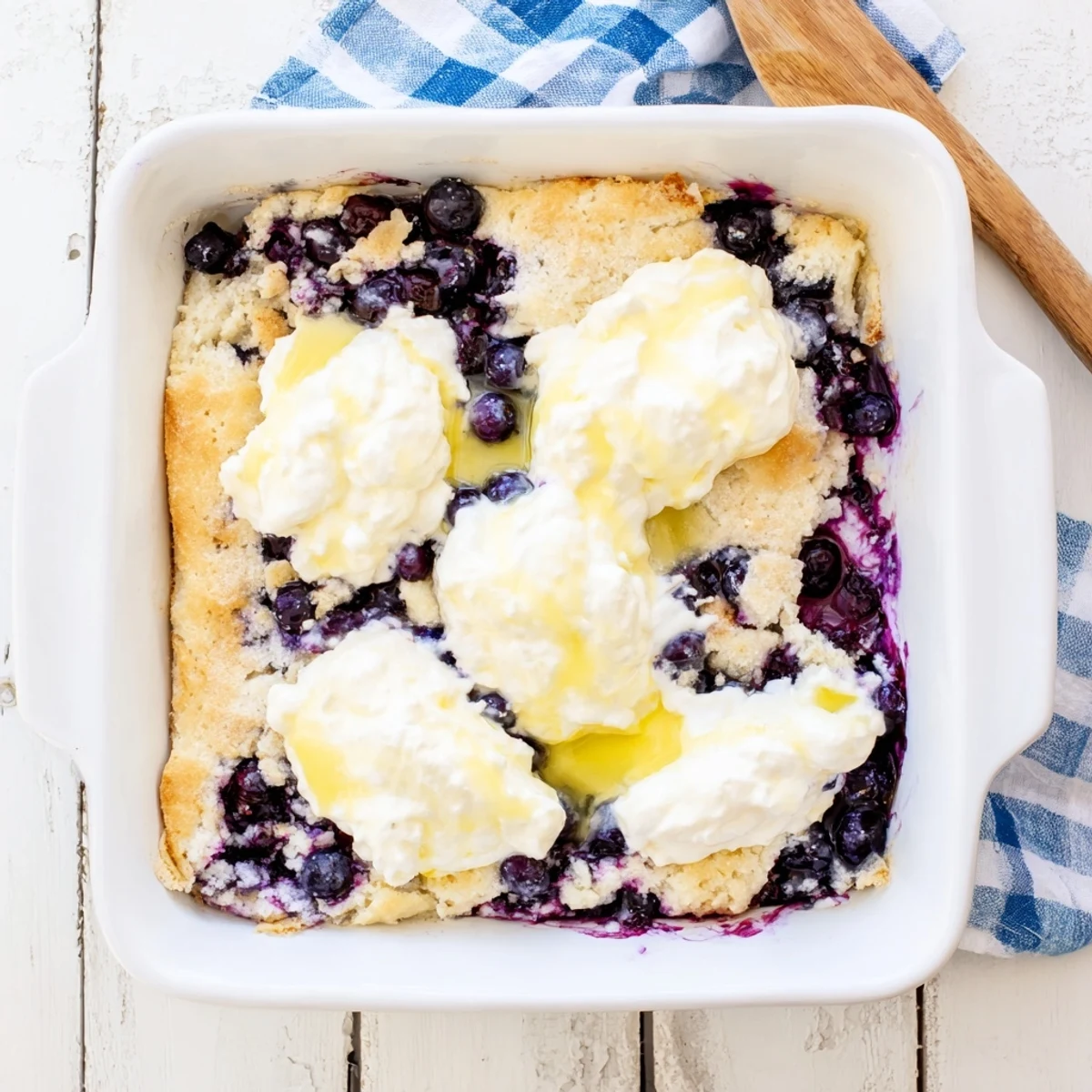 Golden lemon blueberry cheesecake dump cake with bubbling fruit filling and buttery crumbled topping