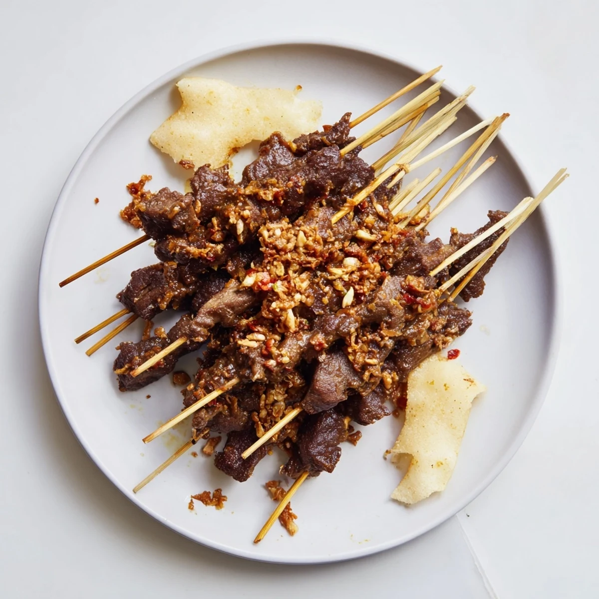 Tender beef skewers served over thick aromatic Padang curry sauce with fried shallot garnish