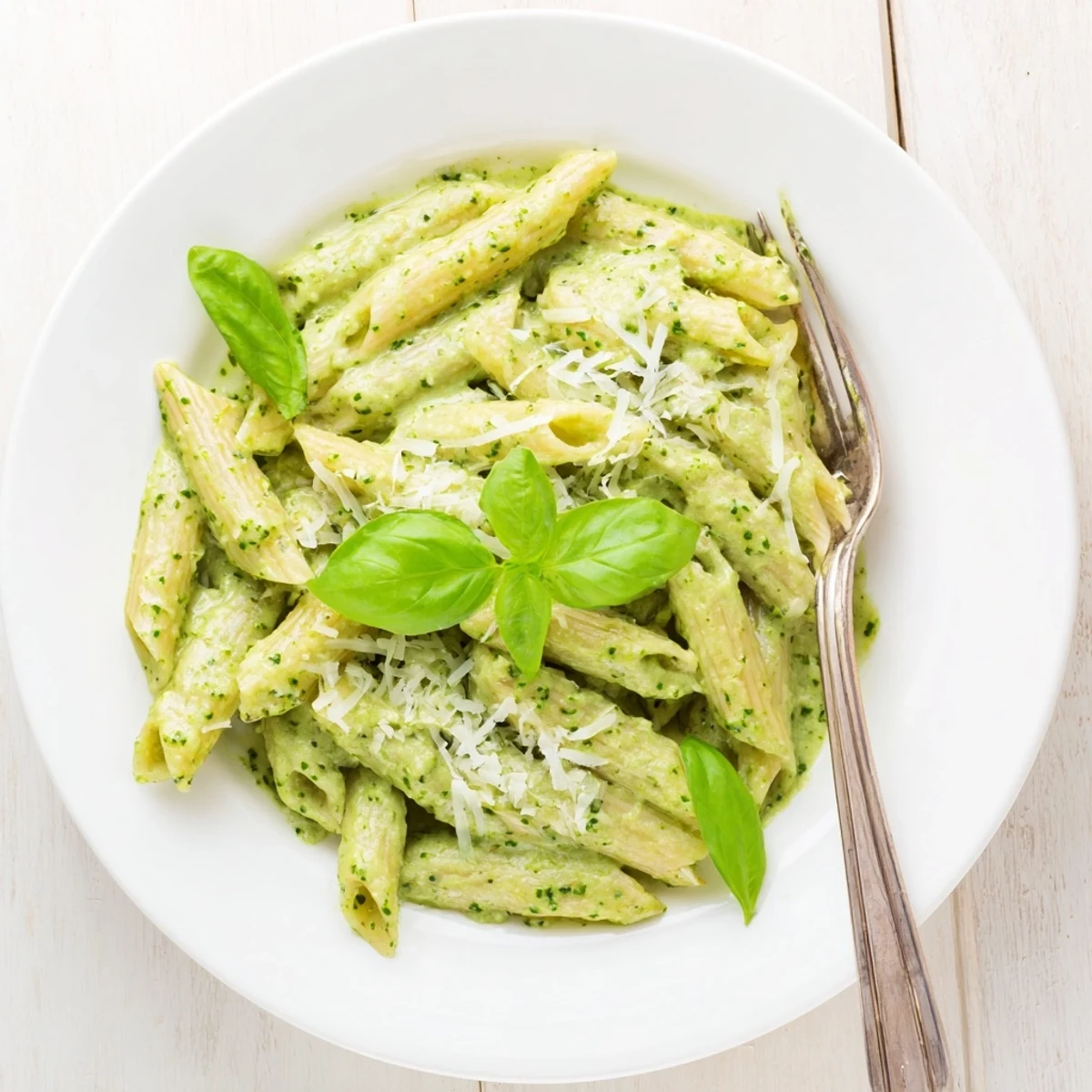 Creamy pesto pasta coated in rich basil sauce with grated Parmesan cheese garnish