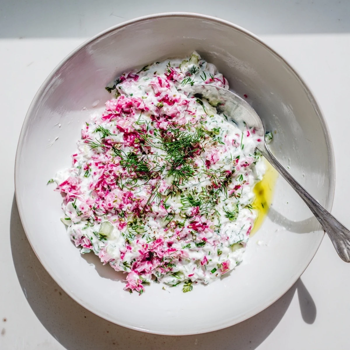 Mediterranean healthy radish tzatziki dip featuring Greek yogurt, grated radishes, and cucumber alongside pita bread slices