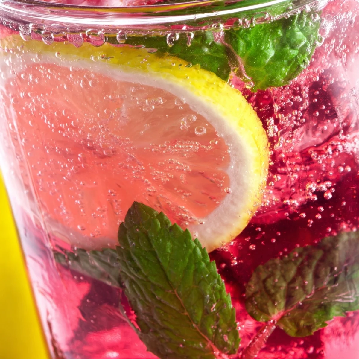 Sparkling Honey Lemon Pink Soda in a tall glass garnished with bright citrus wedges