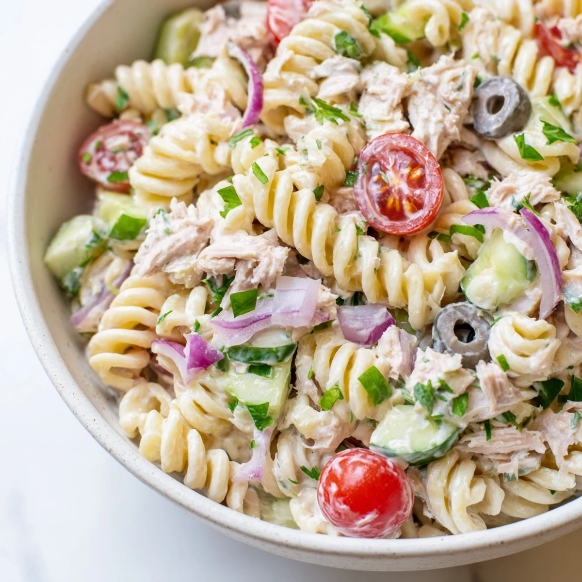Tuna pasta salad featuring flaky tuna, colorful veggies, and rich creamy coating