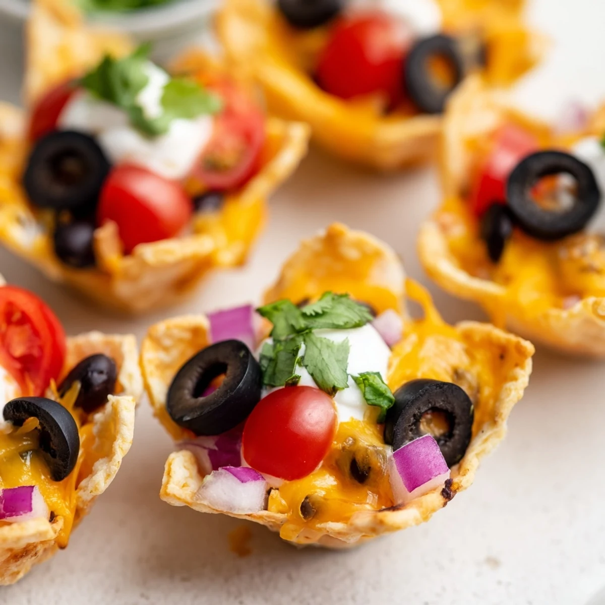 Golden cheesy nacho cups bubbling with melted cheddar and fresh colorful toppings