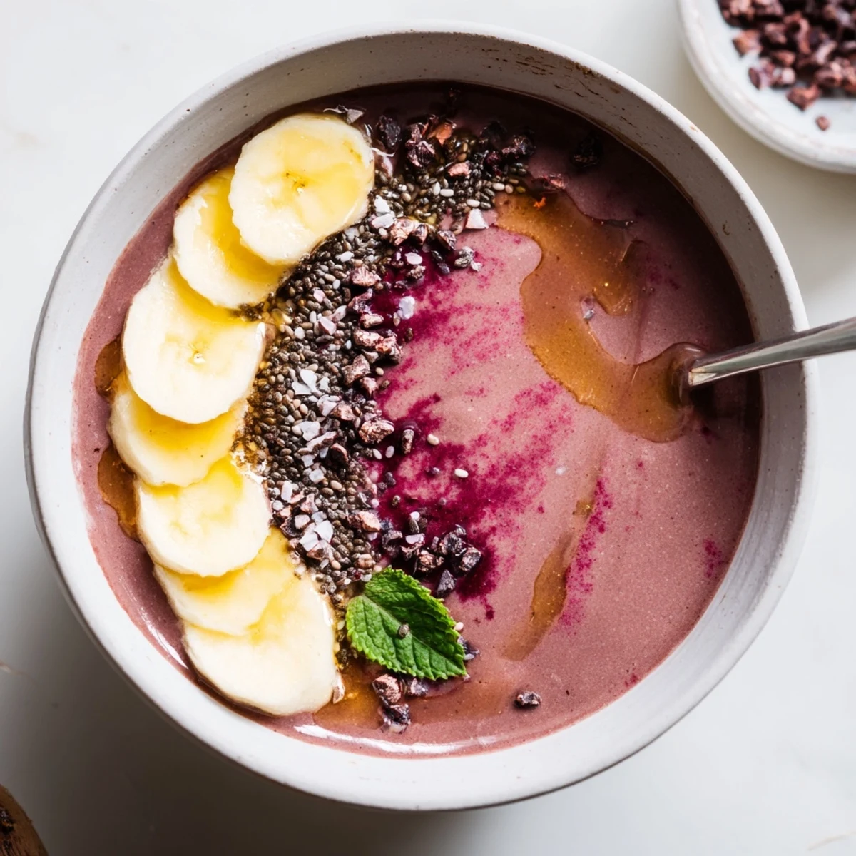 Creamy Chocolate Beet Smoothie in tall glass garnished with mint and cacao