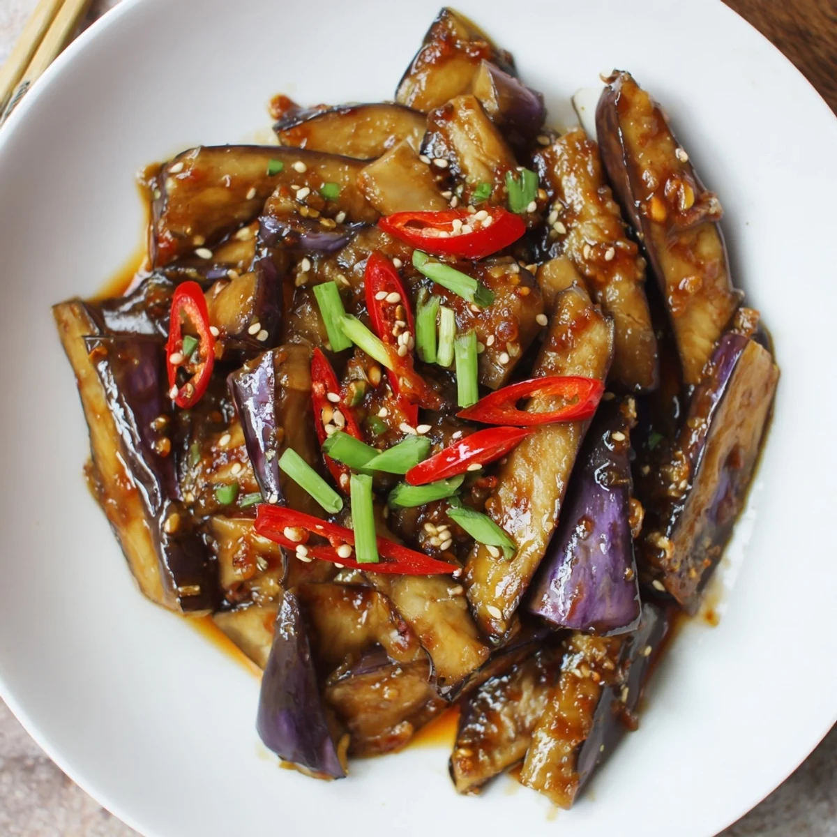 Sichuan Style Braised Aubergines glistening in spicy red sauce over jasmine rice