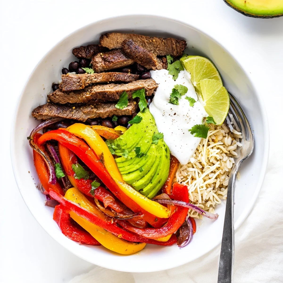 Colorful Steak Fajita Power Bowls: lime wedges, warm rice, tangy cilantro