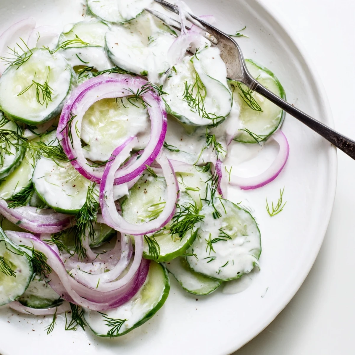 Crisp cucumber dill salad featuring red onions and tangy sour cream topping