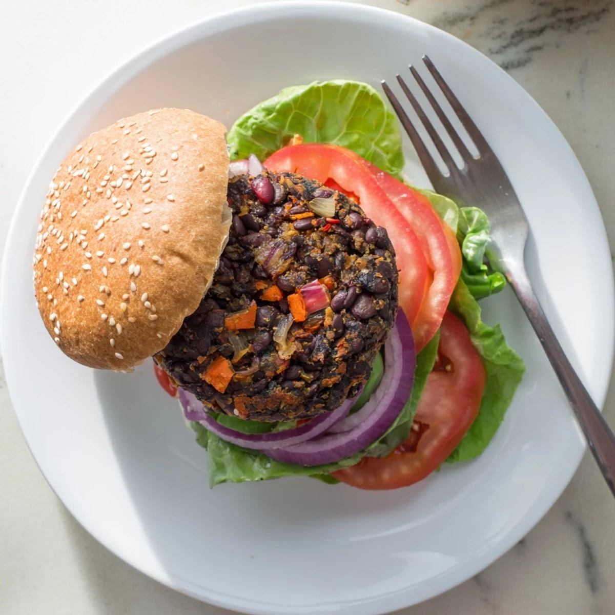 Mouthwatering plant-based veggie burger recipe served on sesame seed bun topped with melted cheese crisp pickles and onion rings