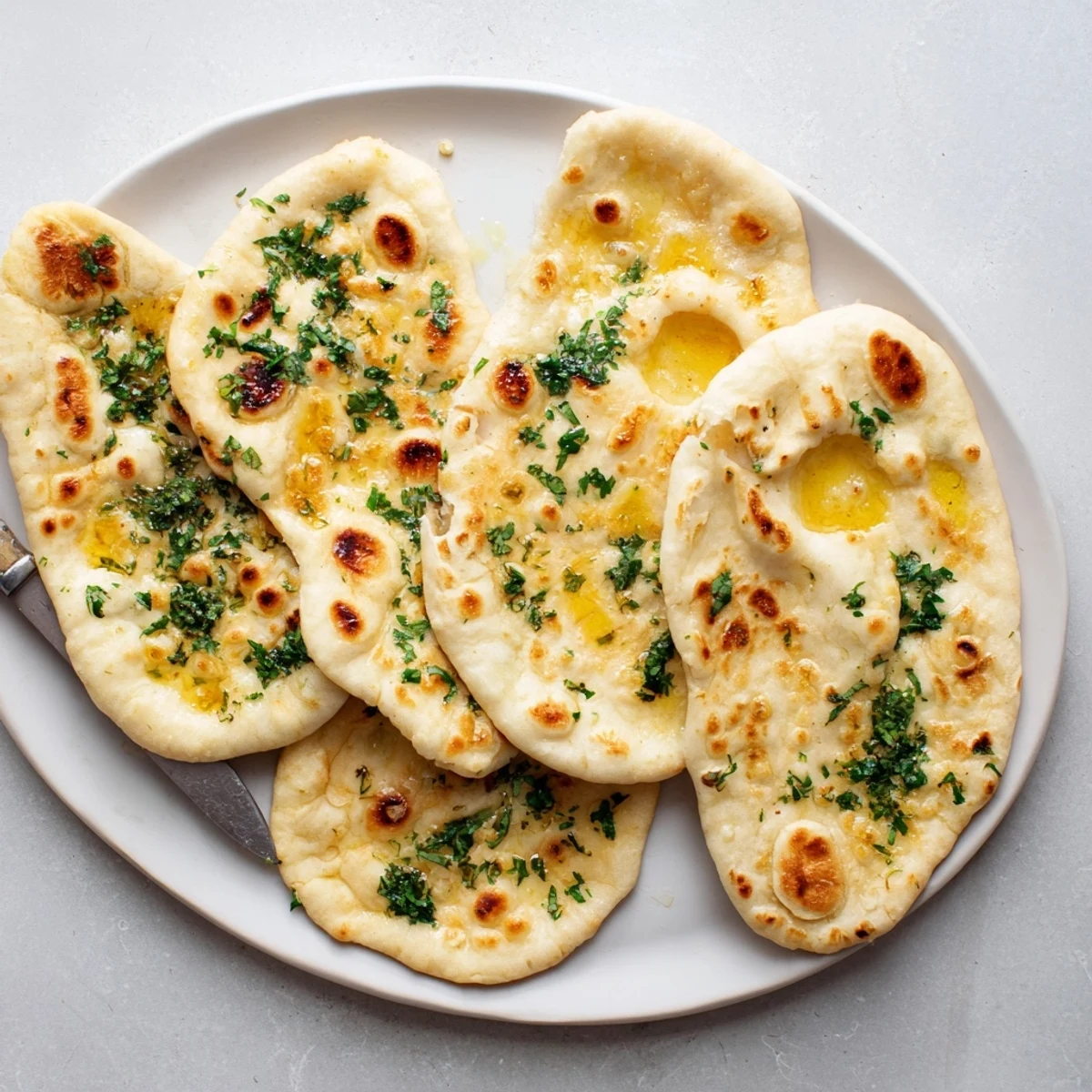 Golden brown sourdough discard soft naan brushed with melted butter and fresh cilantro