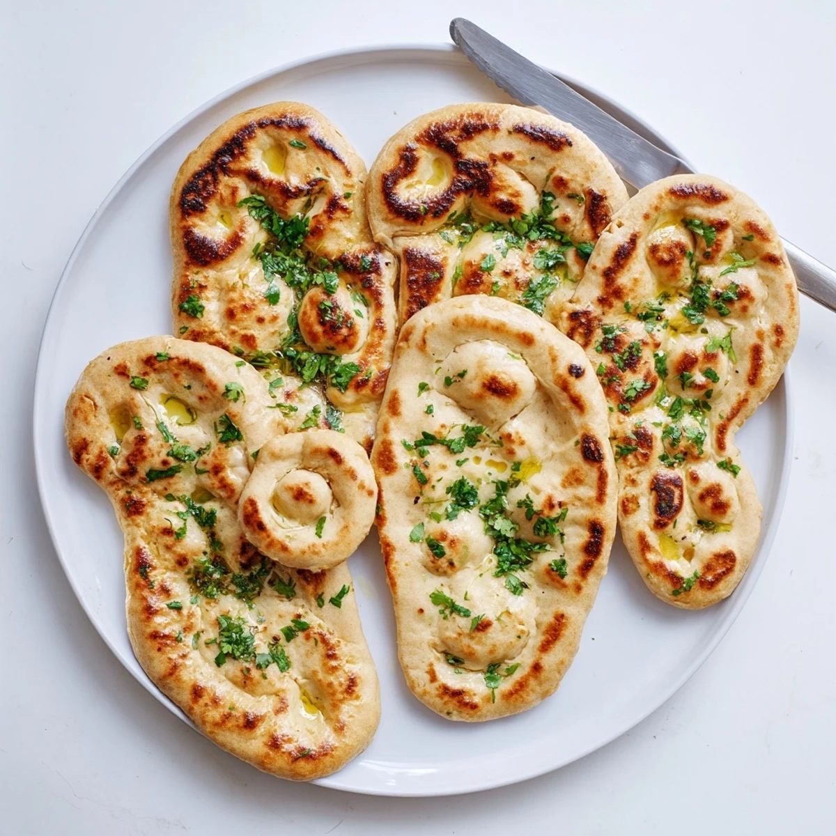 Pillowy Indian-style flatbread with charred bubbles perfect for dipping in savory curry sauce