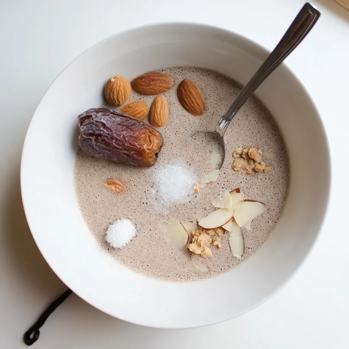 Chilled Almond Milk poured into mug beside cereal bowl, smooth texture